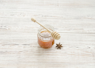 Jar of honey and stick with anise