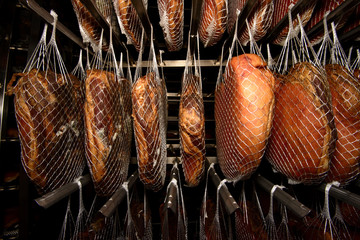 Smoked Ham hanging in seasoning cell