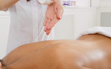 Massagist make oil body massage in spa wellness center