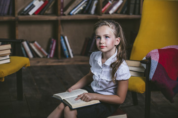 Girl child in the library with books in a strict fashion is enga
