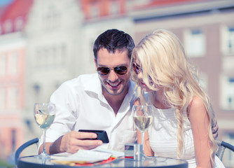 couple looking at smartphone in cafe