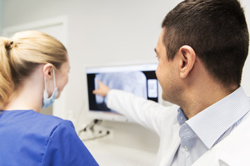 close up of dentist and assistant at dental clinic