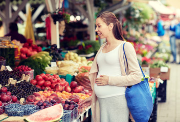 pregnant woman choosing food at street market