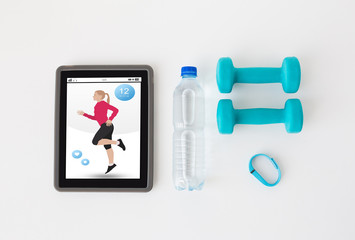 tablet pc, dumbbells, fitness tracker and bottle