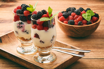 Healthy yogurt dessert with muesli, raspberries and blackberries .