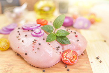 Chicken fillet with spices on a cutting board.