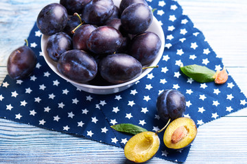 Fresh organic plums in ceramic bowl
