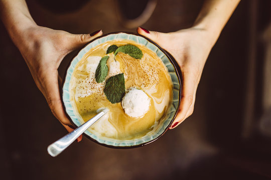 Hands holding bowl with cream soup