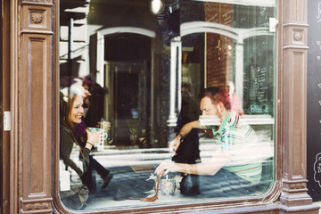 Sweden, Stockholm, Gamla Stan, Friends having coffee, seen through coffee shop window