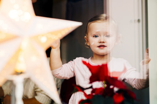 Portrait Of Cute Girl Seen Through Glass Window