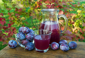 prune juice in the carafe and glass with plums