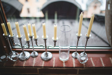 Beautiful white candles standing on the windowsill