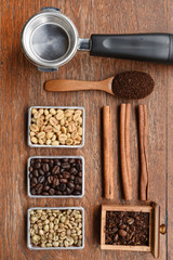 Coffee beans with coffee grinder and ground coffee in wooden spoon on wooden background