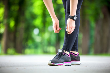Young woman tying her laces before a run.