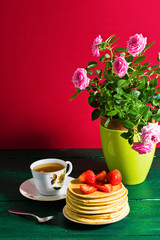 Obraz na płótnie Canvas Traditional breakfast: pancakes with syrup and strawberry, green