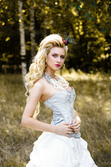 Blonde woman with long curly hair with flower accessory in antique corset and underwear