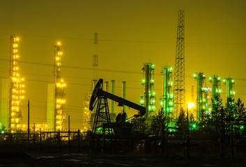 Oil rig at the background of refinery by night. Oil and gas industry. Toned.