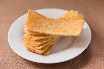 Sliced crispy bread in white ceramic dish.