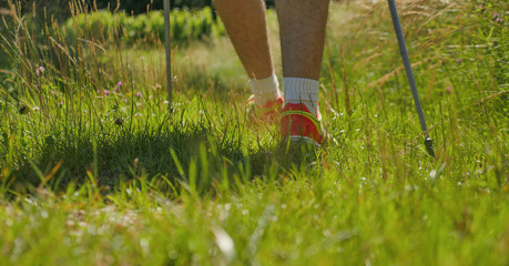 Man walking on sidewalk, sport shoes