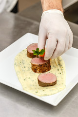 Chef garnishing meat plate