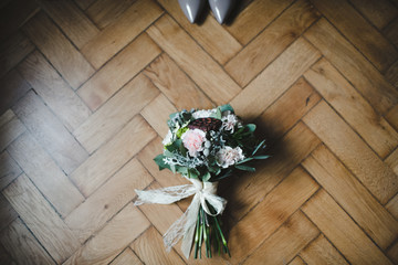 Beautiful bride shoes and wedding bouquet on the floor