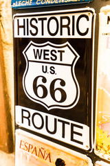 Close-up of black metal signboard with police badge of west 66 route