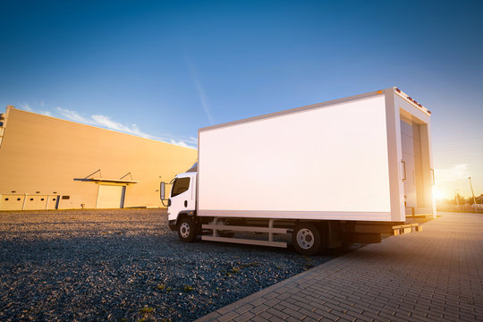 Commercial delivery truck with blank white trailer on cargo parking.