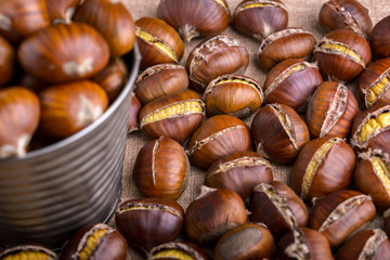 chestnuts in a tin bucket and chestnuts roasted on wood