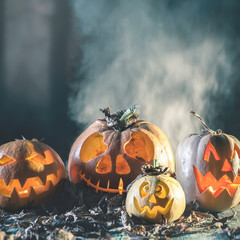 Halloween pumpkins at wood background. Carved scary faces of pumpkin.