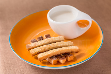 Sliced crispy bread in orange ceramic dish.