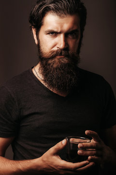 bearded man with glass of brandy or whiskey