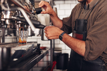 Barista making coffee using a coffee maker