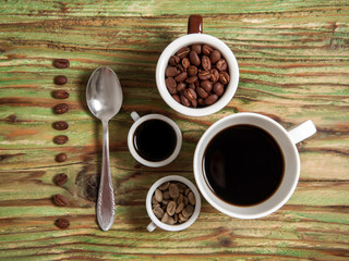 coffee bean in cups and spoon on table