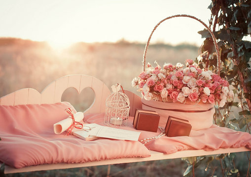 little white candle and big bouquet of roses stand on the bench