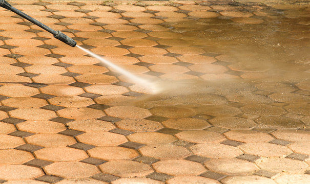 Cleaning concrete block floor by high pressure water jet.