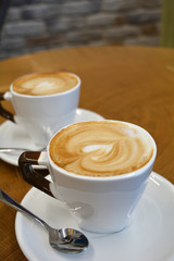 Cup of foamy cappuccino on a wooden table