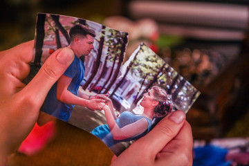 Female hands tearing love photos. Love is gone. On pictures couple in love.