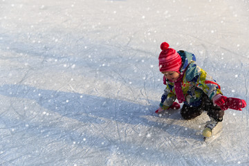 Fototapeta na wymiar cute little girl learning to skate in winter