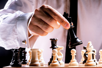 Hand of businessman playing chess