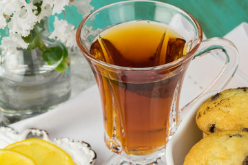 Cup of tea with mini chocolate chip muffins on a tray.