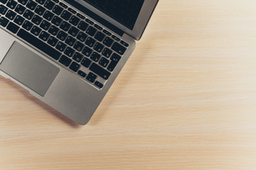 Laptop keyboard on the wooden desk