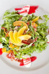 Plate of grilled peach and Mozzarella salad with mixed baby gree