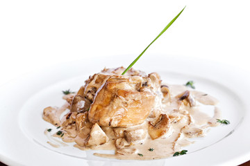 Closeup of fried chicken breast covered with mushroom sauce