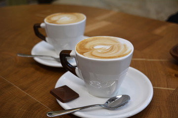 Cup of foamy cappuccino on a wooden table