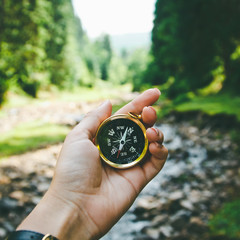 Compass in the hand on the nature background.