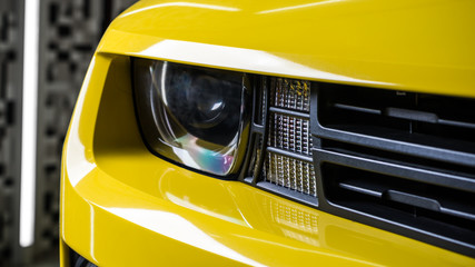 Car detailing series : Closeup of clean yellow car headlights