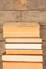 Old and used hardback books or text books on wooden table