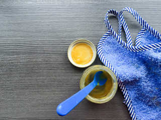 Leeres Glas Babybrei und Lätzchen