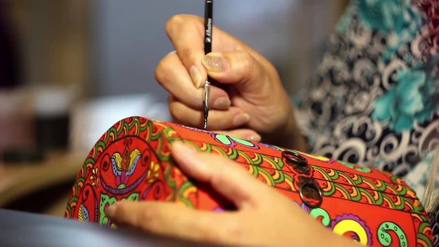 paints with a brush on wood