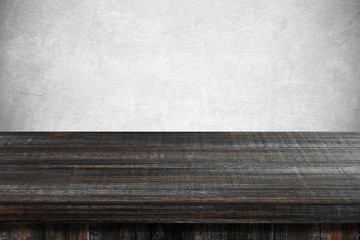 Empty dark wooden table over gray cement wall background